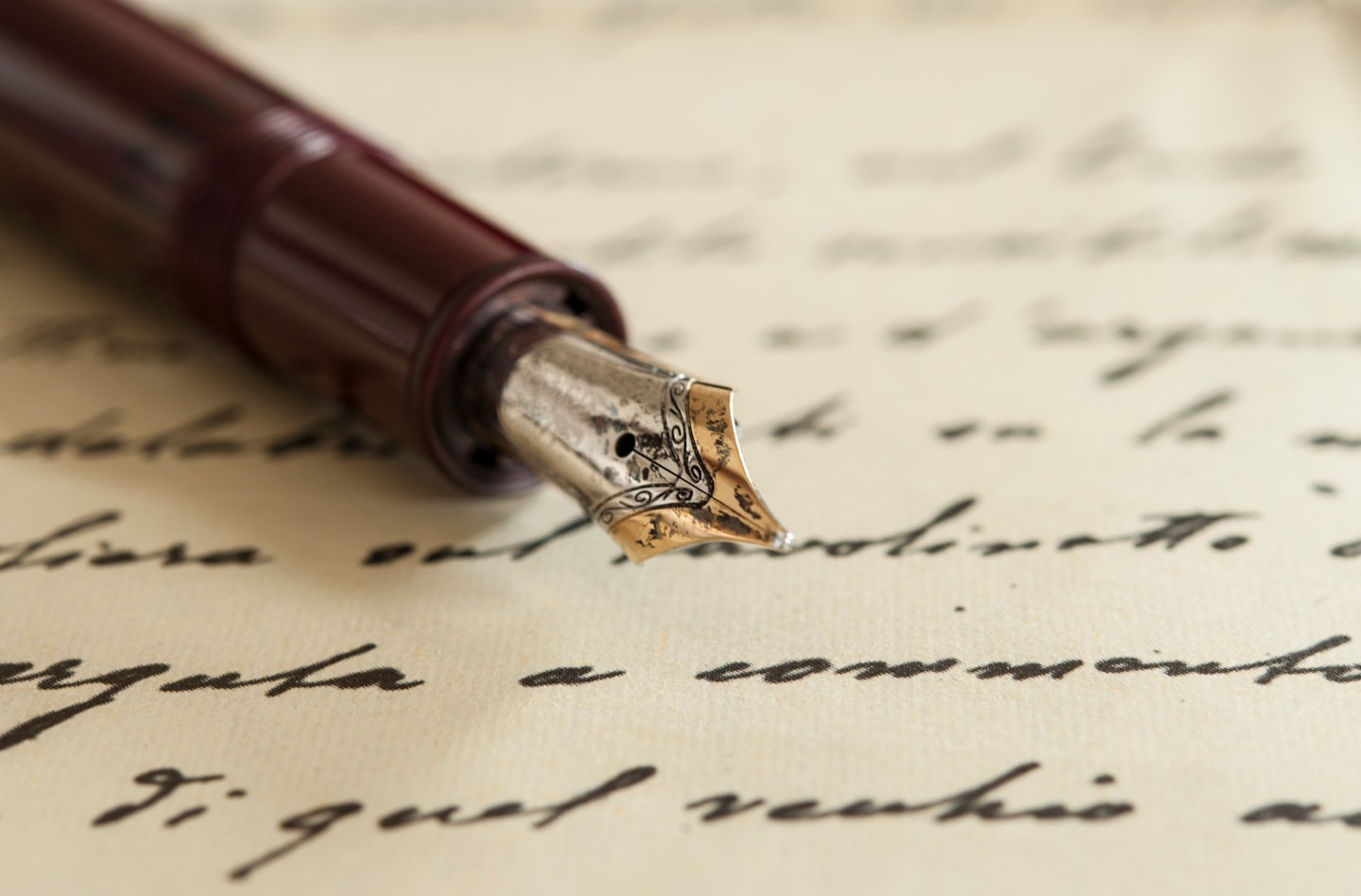 Una penna stilografica su carta color crema con testo scritto a mano.