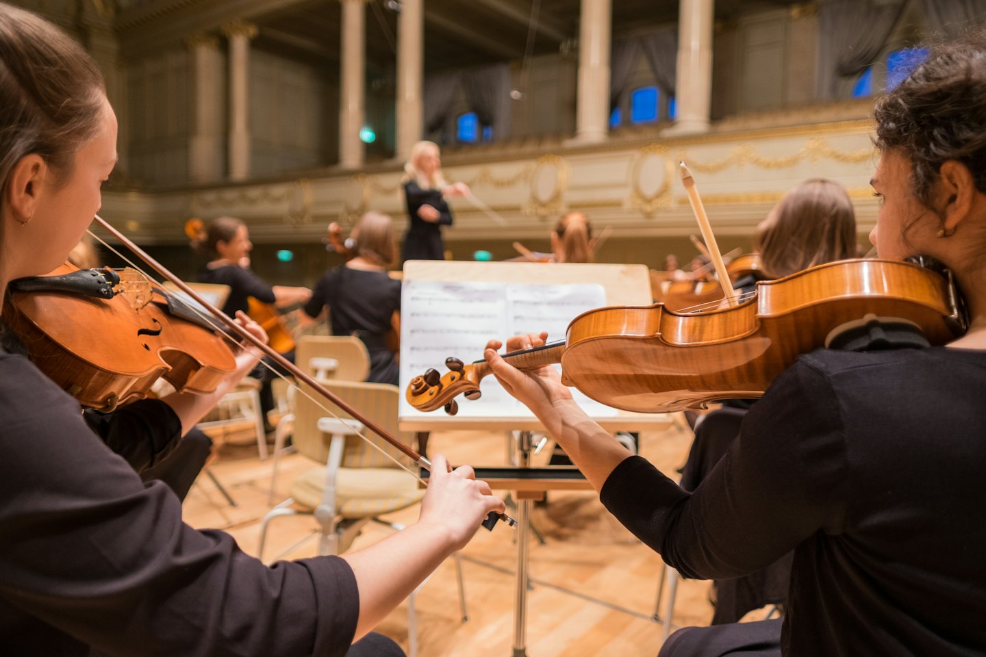 Due violinisti suonano intensamente i loro strumenti durante una prova.